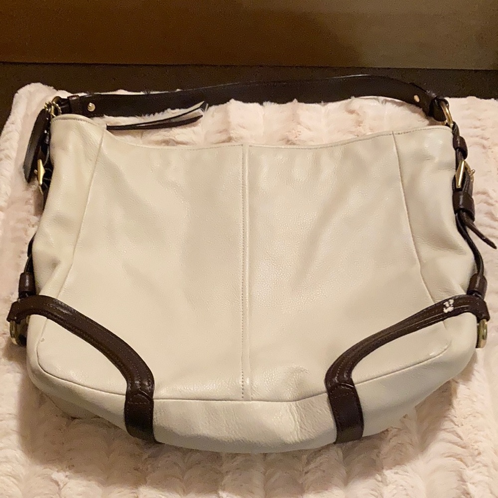 This is a cream color, medium size Coach handbag.